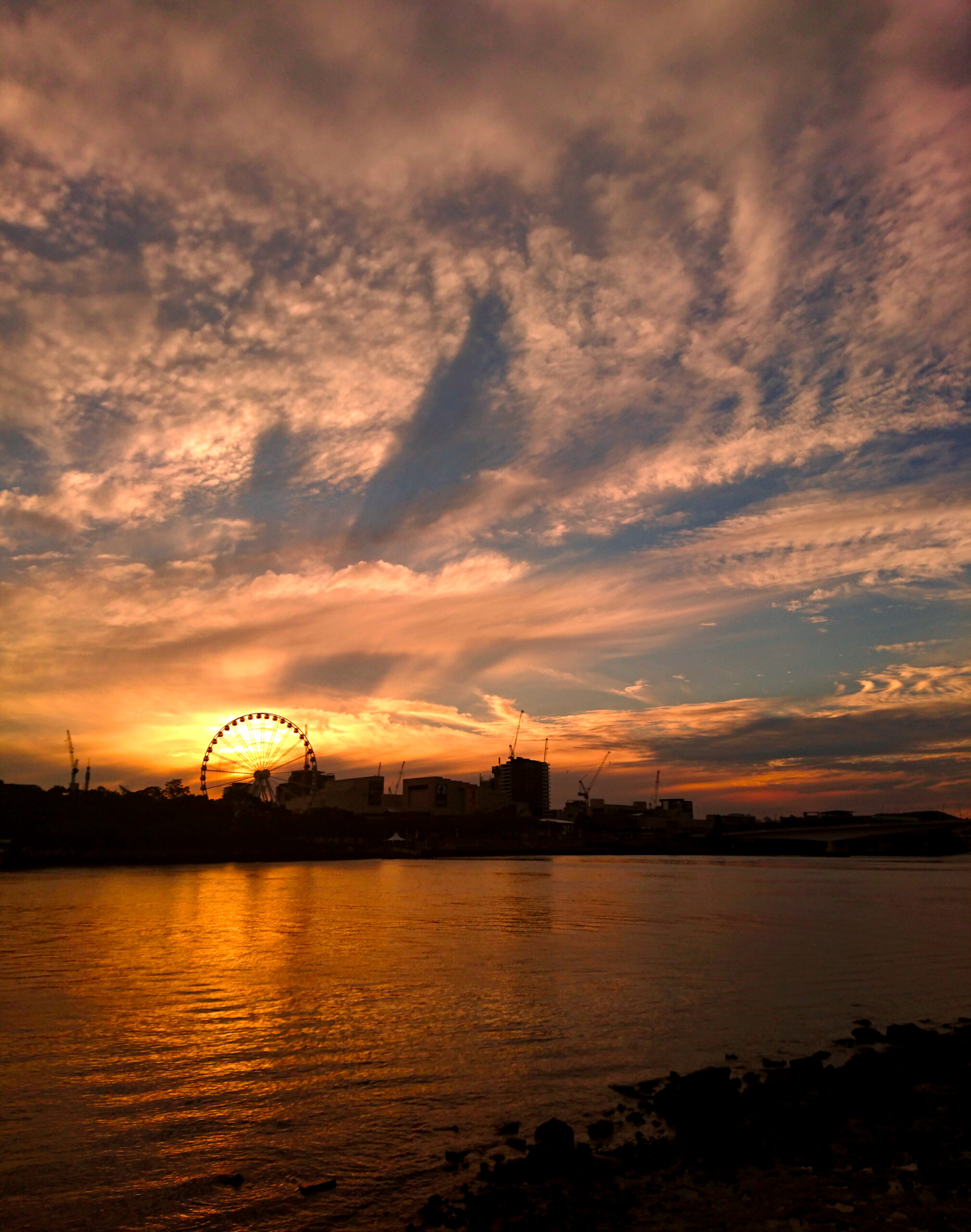ブリスベン川に沈む夕日と観覧車Wheel of Brisbaneのシルエット